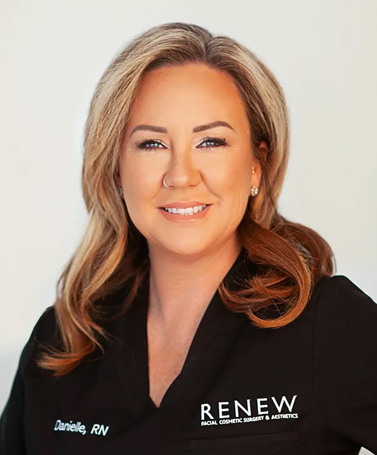 Professional woman in medical uniform smiling.