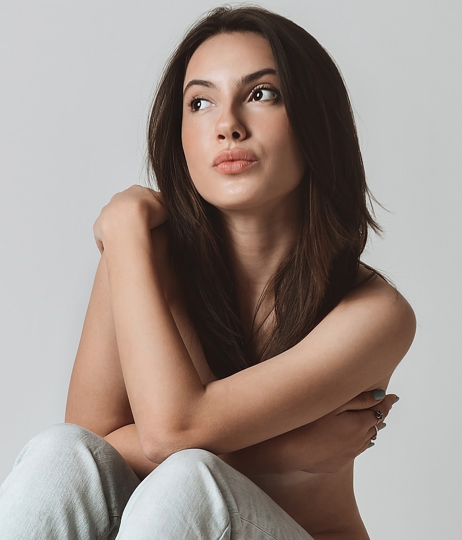 Model posing thoughtfully against a neutral backdrop.
