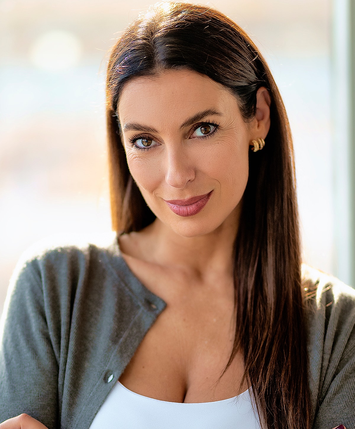 Melbourne blepharoplasty model smiling in a casual, professional setting.