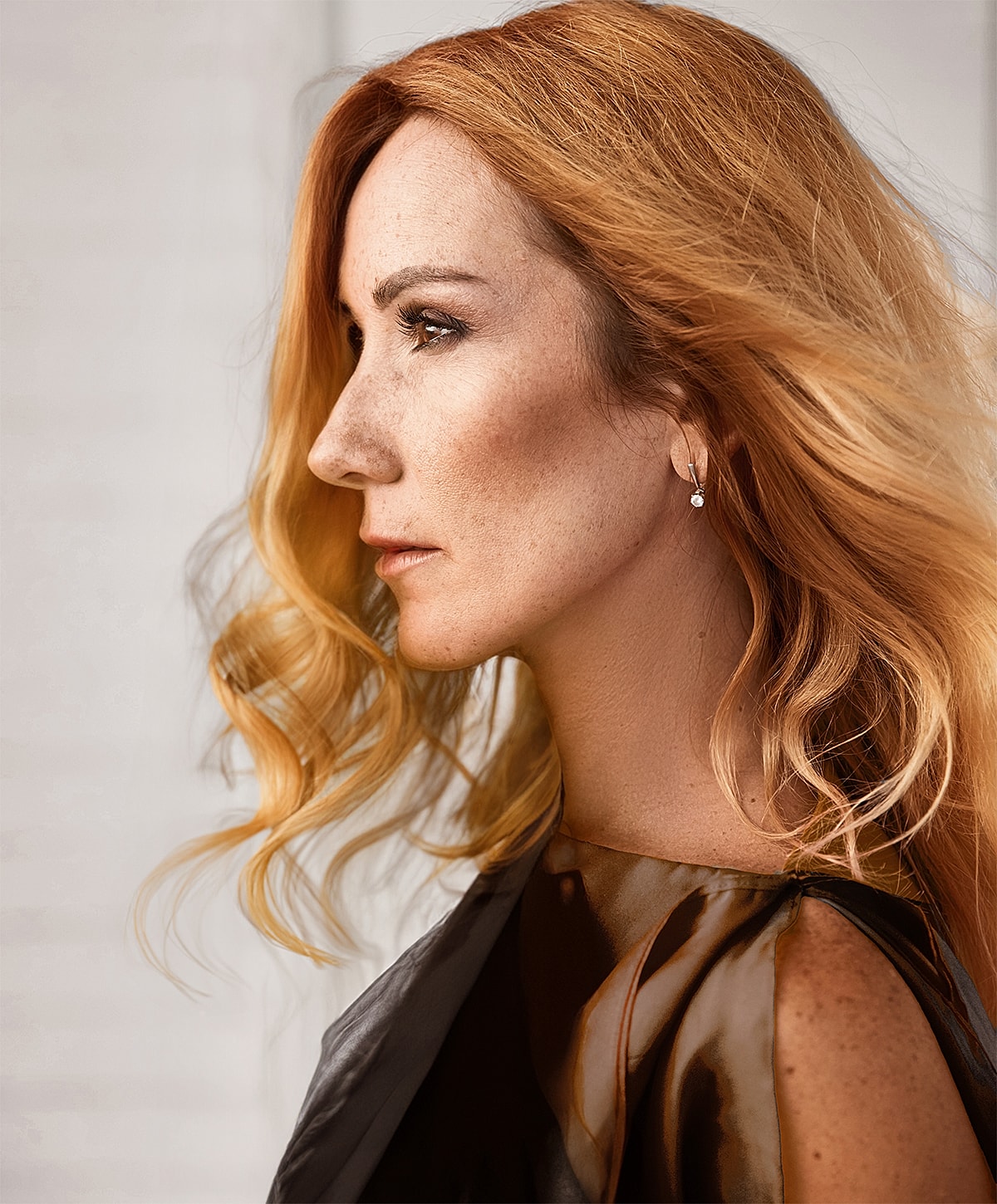 Woman with long, wavy red hair in profile.