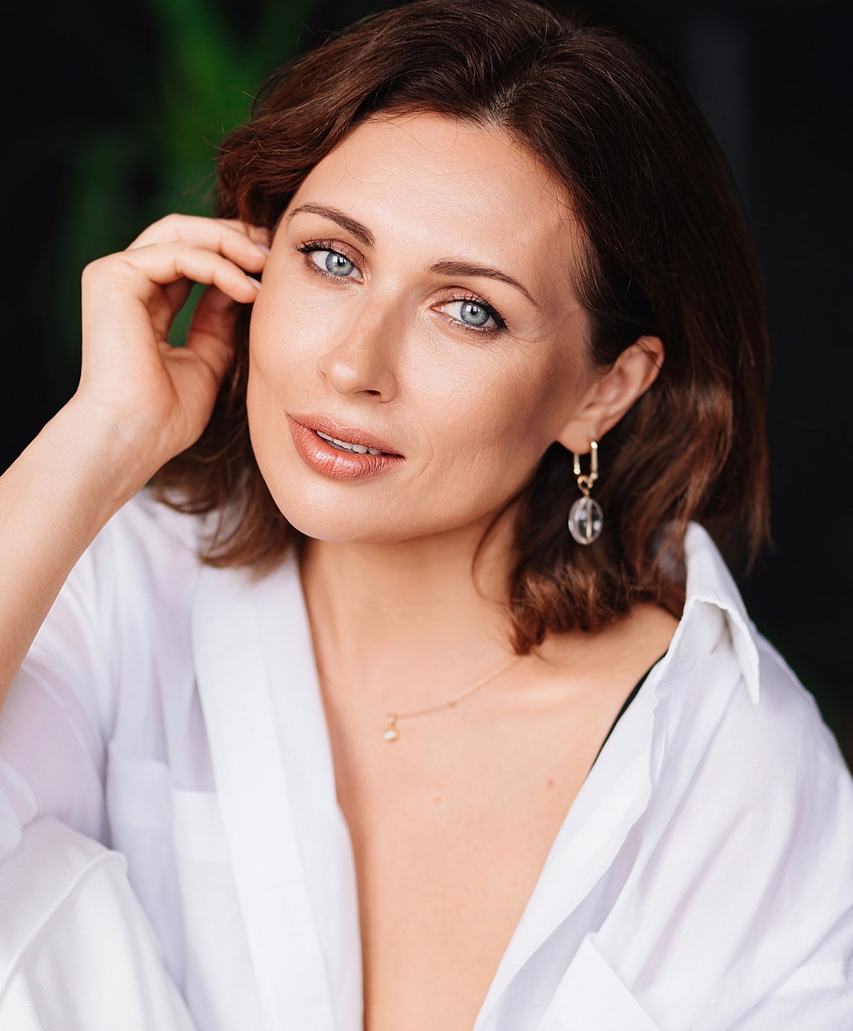 Woman in a white shirt smiling softly.