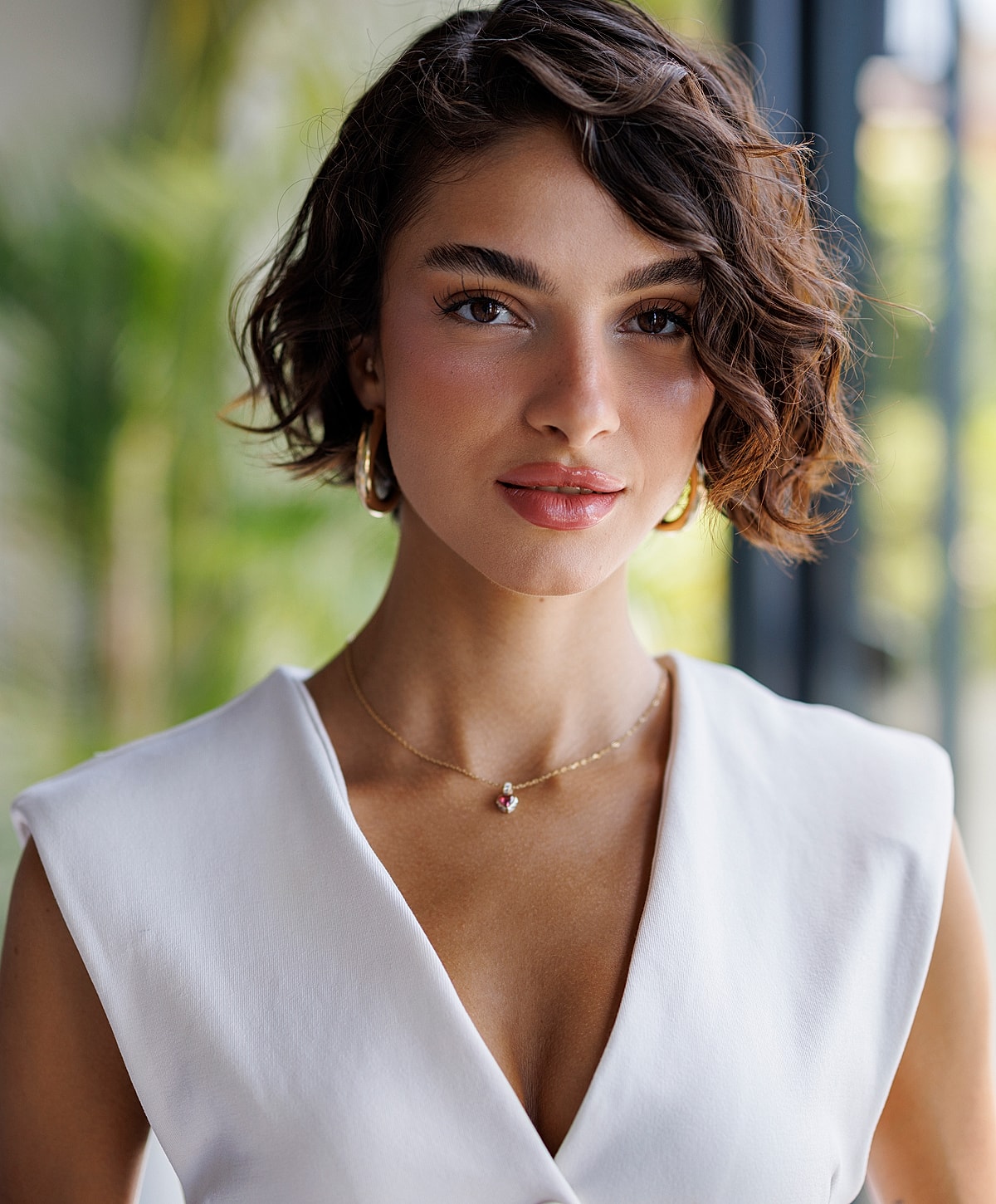 Melbourne dermal filler model in a white blouse with curly hair.
