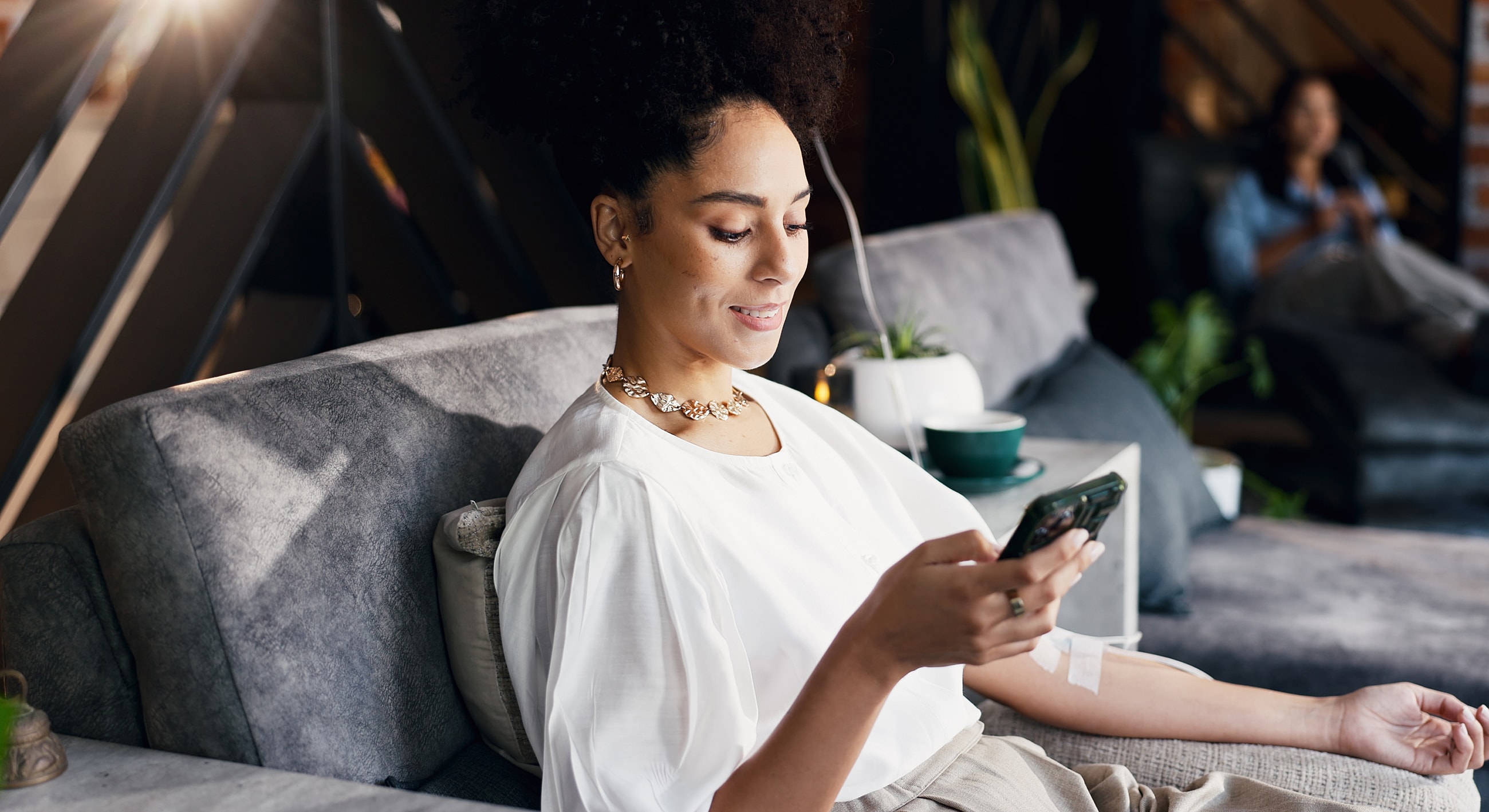 Woman using phone while sitting on couch.